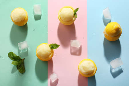 Tasty ice creams in lemon peels on color backgroundの写真素材