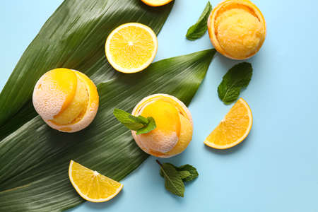 Tasty ice creams in orange peels on color backgroundの写真素材