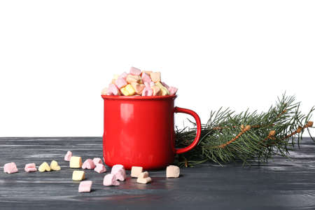 Cup of cocoa with marshmallows and fir branches on table against white background. winter conceptの写真素材