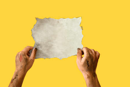 Hands of zombie with empty paper sheet on color backgroundの写真素材
