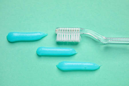 Samples of toothpaste and brush on turquoise background, closeupの写真素材