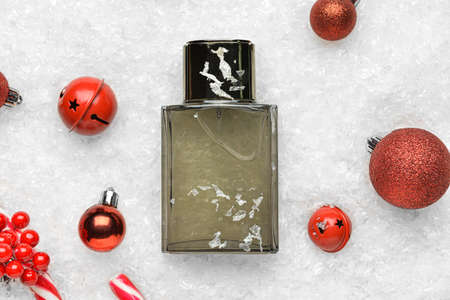 Bottle of perfume, Christmas balls and bells on snow backgroundの写真素材