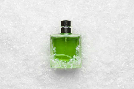Bottle of perfume in snow on light backgroundの写真素材