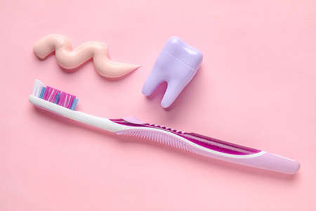 Sample of paste, plastic tooth and brush on pink backgroundの写真素材