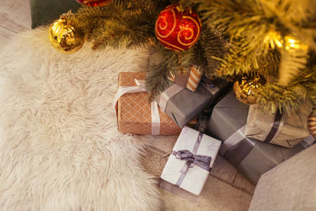 Many gifts under Christmas tree on floor