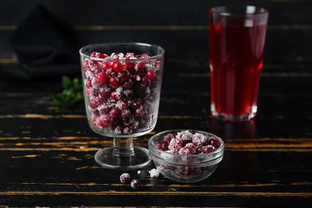 Bowls with tasty sugared cranberries on black wooden backgroundの写真素材
