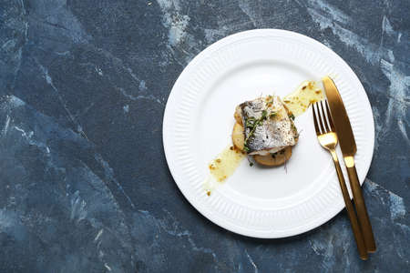 Plate of delicious sea bass fish on blue backgroundの写真素材