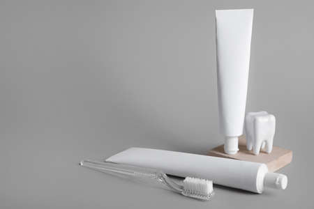 Composition with toothpaste tubes and toothbrush on gray backgroundの写真素材