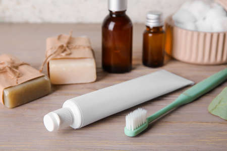 Toothbrush, paste and bath supplies on wooden tableの写真素材