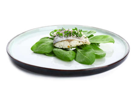 Plate of tasty sea bass fish on white background