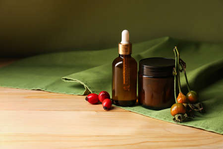 Natural cosmetics with rose hip extract on wooden tableの写真素材