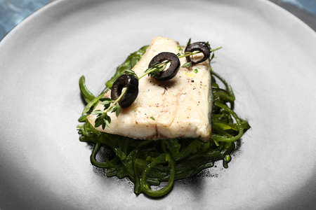 Plate of delicious sea bass fish on table, closeup