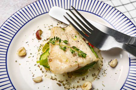 Plate of delicious sea bass fish on table, closeup