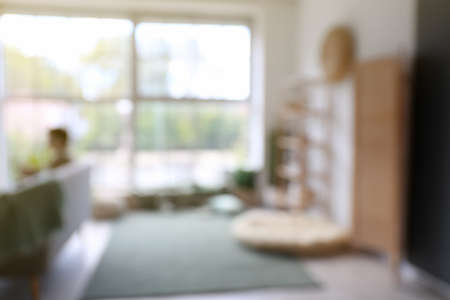 Blurred view of man sitting on sofa at homeの写真素材