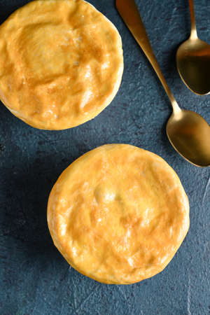 Tasty vegetable pot pies on black background