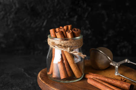 Jar of natural cinnamon sticks on black backgroundの写真素材