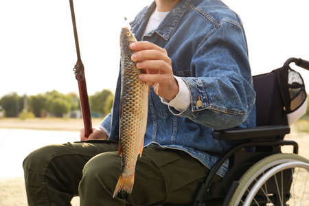 Man in wheelchair fishing on river