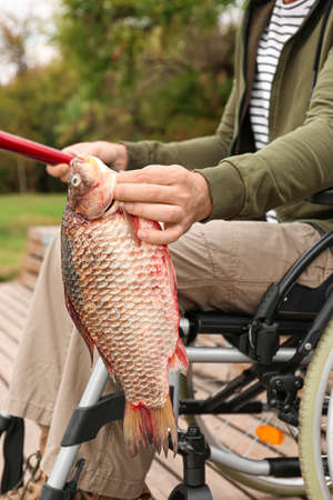 Man in wheelchair fishing on river