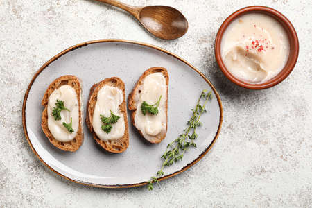 Bowl of lard spread and bread on light background