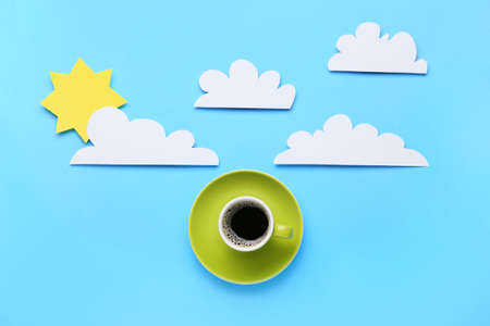 Creative composition with cup of coffee, paper clouds and sun on color background