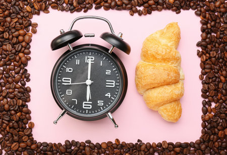 Composition with coffee beans, croissant and alarm clock on pink background, closeup