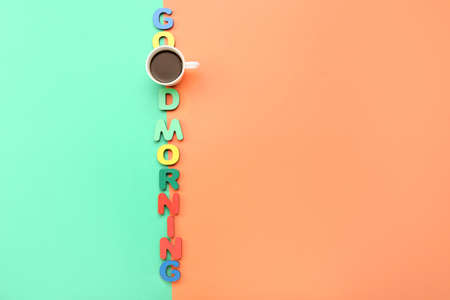 Cup of coffee and text GOOD MORNING on color backgroundの写真素材
