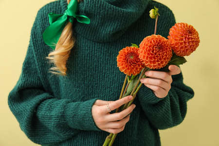 Woman holding beautiful dahlias on color background, closeupの写真素材
