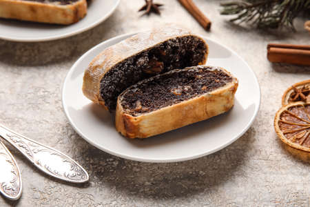 Plate with pieces of tasty poppy seed strudel on light backgroundの写真素材