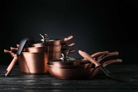 Set of kitchen utensils on wooden table against dark backgroundの写真素材