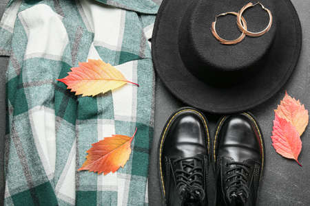 Female accessories, clothes and dry leaves on dark background, closeup