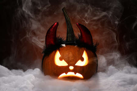 Carved pumpkin for Halloween on dark background