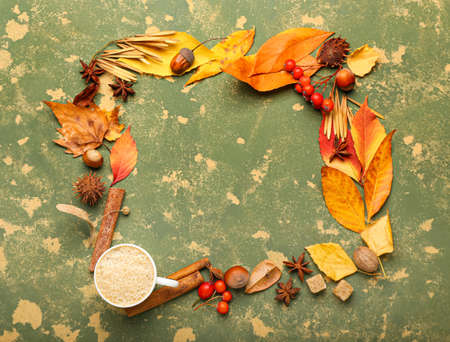 Frame made of autumn composition with cup of coffee on color grunge background