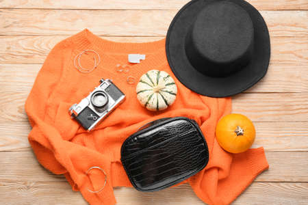 Stylish sweater, female accessories and photo camera on wooden backgroundの写真素材