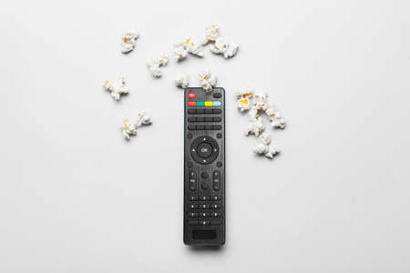 Modern TV remote control and popcorn on white backgroundの写真素材