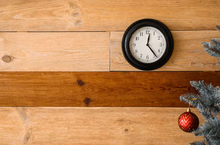 Christmas tree and black clock on wooden wallの写真素材