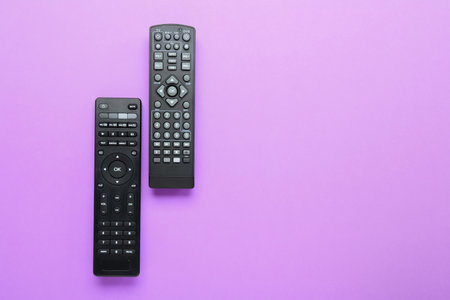 Modern TV remote controllers on color backgroundの写真素材