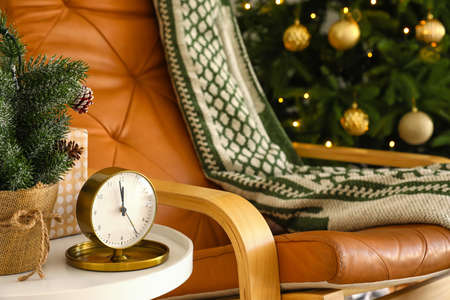 Christmas fairy time. Golden alarm clock on coffee table in room