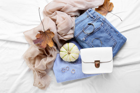 Pumpkin, stylish jeans and female accessories on fabric backgroundの写真素材