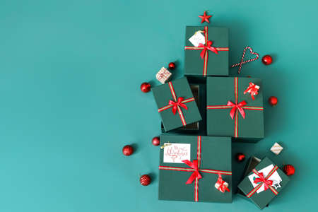 Christmas tree made of gift boxes and balls on green backgroundの写真素材