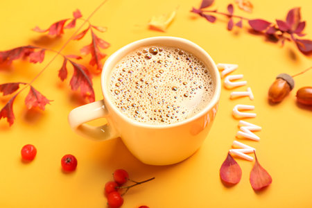 Autumn composition with cup of coffee and text AUTUMN on color background