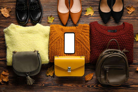 Different shoes, sweaters, bags and mobile phone on wooden background. black friday saleの写真素材