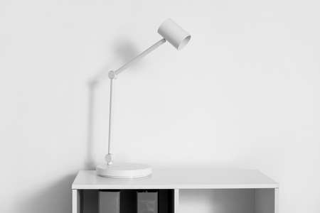 Modern white lamp on shelf near light wall in officeの写真素材