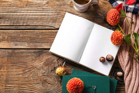 Blank book, cup of tea and flowers on wooden backgroundの写真素材