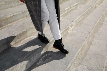 Stylish woman in boots going downstairs outdoors, closeupの写真素材