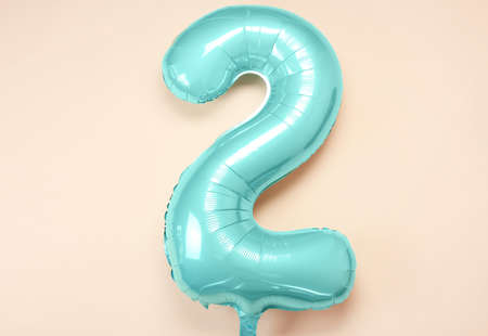 Green balloon in shape of figure 2 on color background