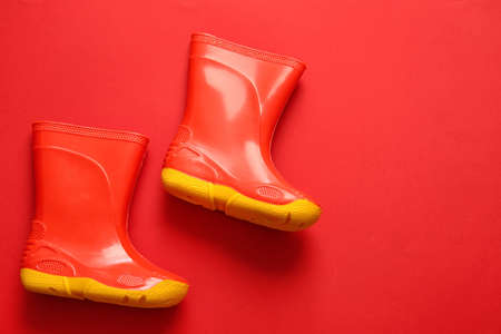 Pair of rubber boots on red backgroundの写真素材