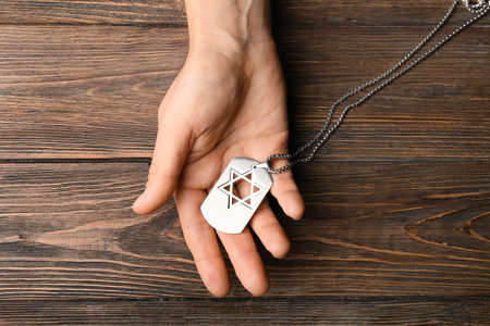 Hand with military tag of Israeli soldier on wooden backgroundの写真素材