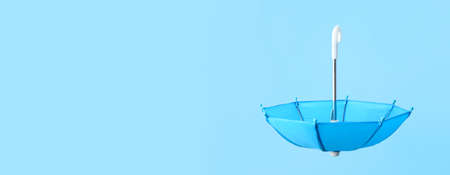 Open umbrella on light blue background with space for textの写真素材