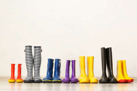 Many different rubber boots on floor near light wallの写真素材