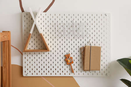 Pegboard with decor, rattle and books hanging on color wall in children's roomの写真素材